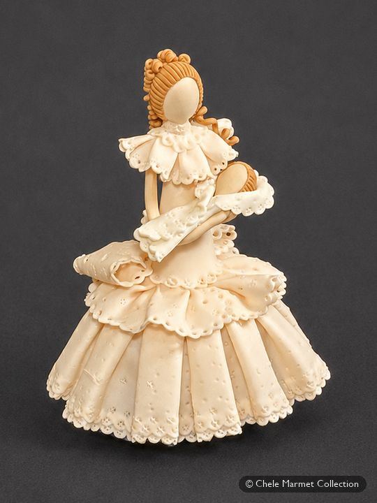 Porcelain figure of a woman in a cream lace-textured gown with pink trim, holding a baby.