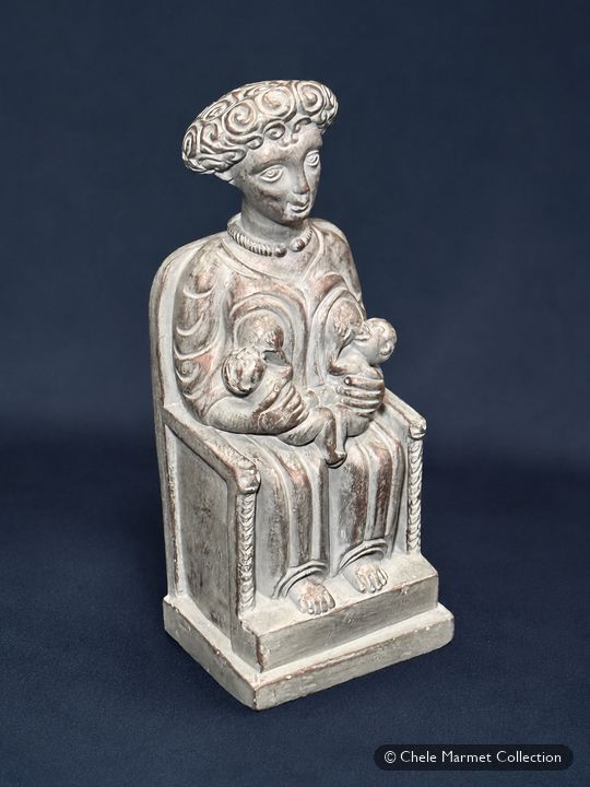 Pale grey figure of a woman in a tall headdress, seated on a throne with a child on her lap.