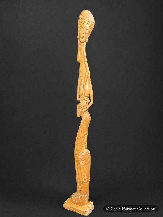 Tall, slender carved wooden figure of a mother nursing a baby, with a small child at her feet.