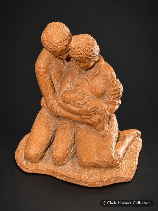 Terracotta sculpture of a kneeling couple embracing a baby between them.