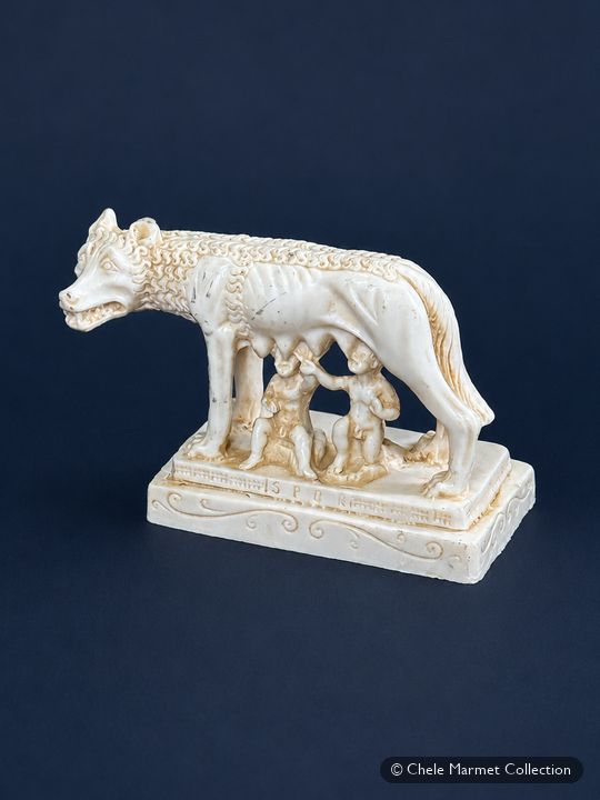 Ivory-coloured statuette of the she-wolf with the twins Romulus and Remus nursing beneath her.