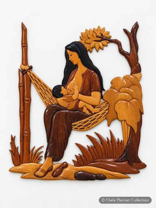 Carved wooden wall panel of a long-haired woman nursing a baby in a hammock strung between trees.