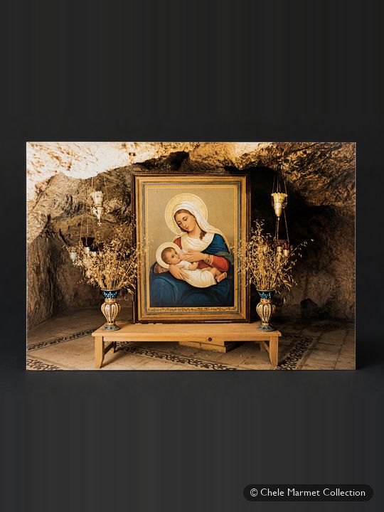 Postcard of a painting of the Madonna nursing the Christ child, displayed in a rock grotto between vases.