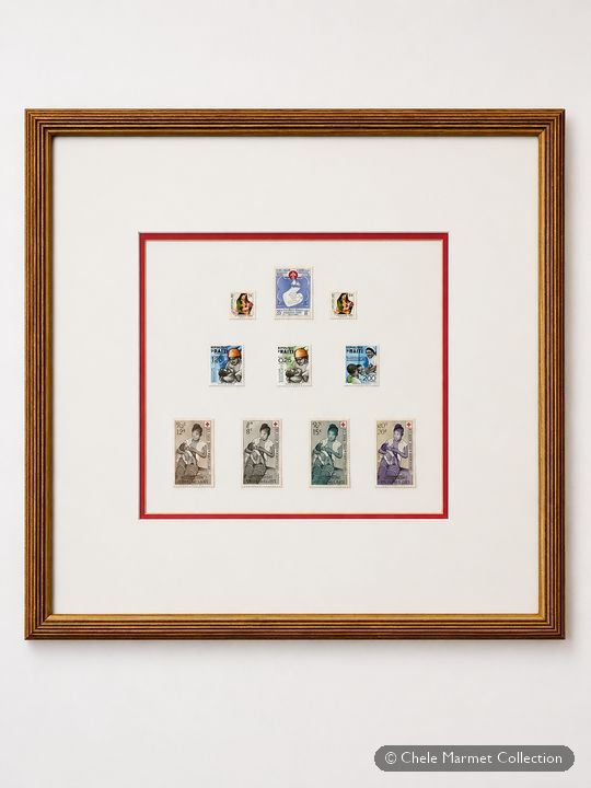 Framed white mat with a red border holding a small grid of stamps.