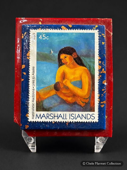 Stamp from the Marshall Islands of a woman holding a baby, mounted on a blue and red card.