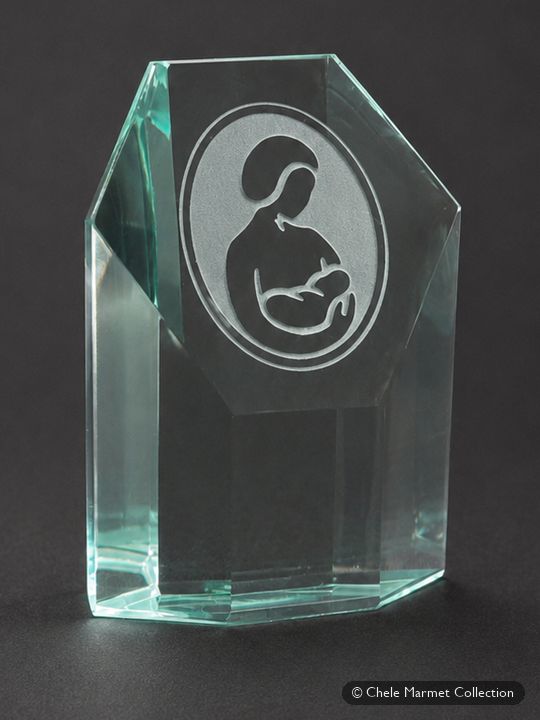 Faceted green-tinted glass paperweight etched with the La Leche League International mother-and-baby logo.