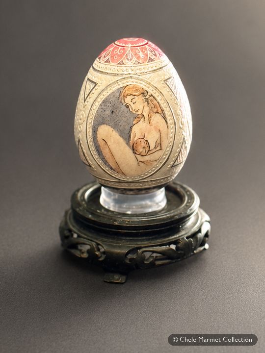 Hand-painted eggshell on a black stand, painted with a mother and baby.